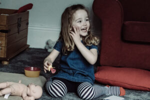 A girl plays with her toys during a family photoshoot taken by Sophie Ransome Lifestyle Photographer