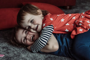 Sisters hug during a family session with Sophie Ransome Lifestyle Photographer