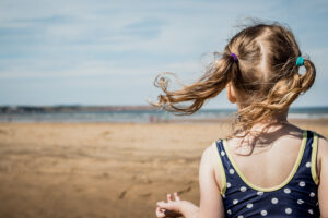A girl at the beach, unscripted family photograph by Sophie Ransome Lifestyle Photographer