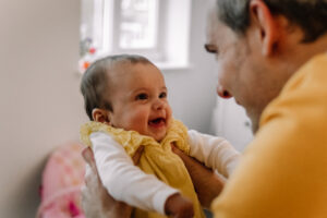 Baby smiling at her dad during family photoshoot with Sophie Ransome Lifestyle Photographer