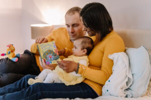 Parents read to their baby during a family photo session with Sophie Ransome Lifestyle Photographer