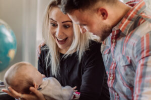 Family photo of a young couple play with baby girl taken by Sophie Ransome Lifestyle Photographer
