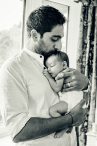 Dad cradles his new baby girl. Image by Sophie Ransome Lifestyle Photographer